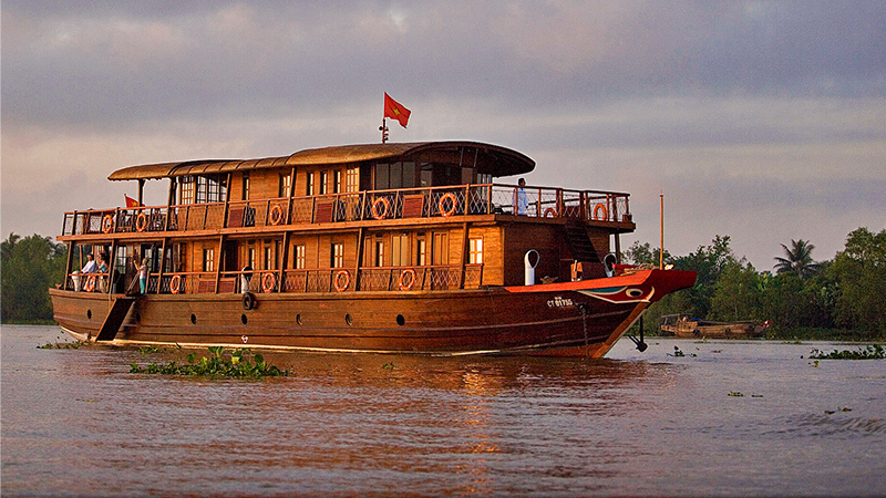 un barco de crucero de madera por el delta del mekong