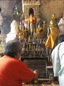 Los turistas se reúnen al pie del altar de la cueva Pak Ou, cerca de Luang Prabang en Laos.