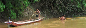 Un niño maniobra su canoa mientras su padre pesca en un brazo del Mekong en Laos