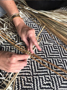 Un viajero participa en un taller de tejido de objetos artesanales en la biorregión de Phatthalung, en Tailandia.