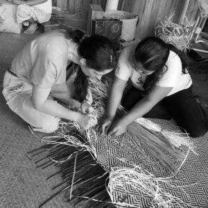 Dos viajeros participan en un taller de tejido de objetos artesanales en la biorregión de Phatthalung, en Tailandia.