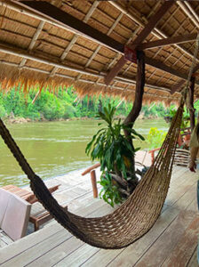 Vue d'un hamac sur le pont d'un hôtel flottant en bambou au cœur de la jungle thaïlandaise