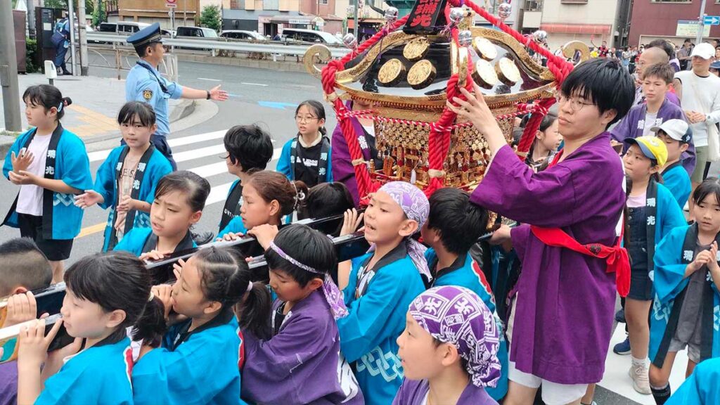 Niños transportando un mikoshi en miniatura durante un festival tradicional en Japón