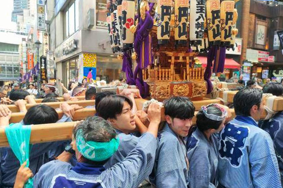 Porteadores transportando un mikoshi entre la multitud durante un matsuri en Tokio