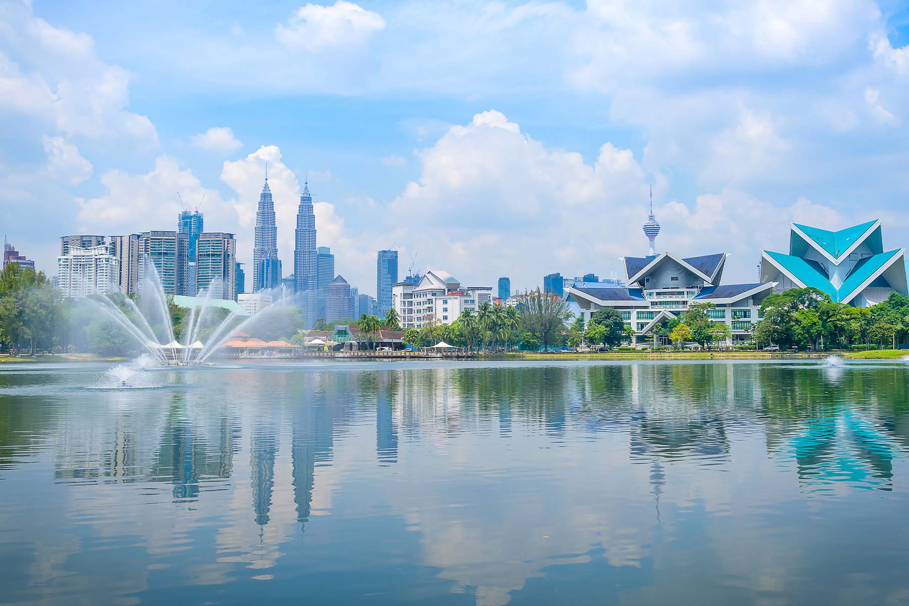 Torres Petronas y horizonte urbano de Kuala Lumpur vistos desde un parque con un lago