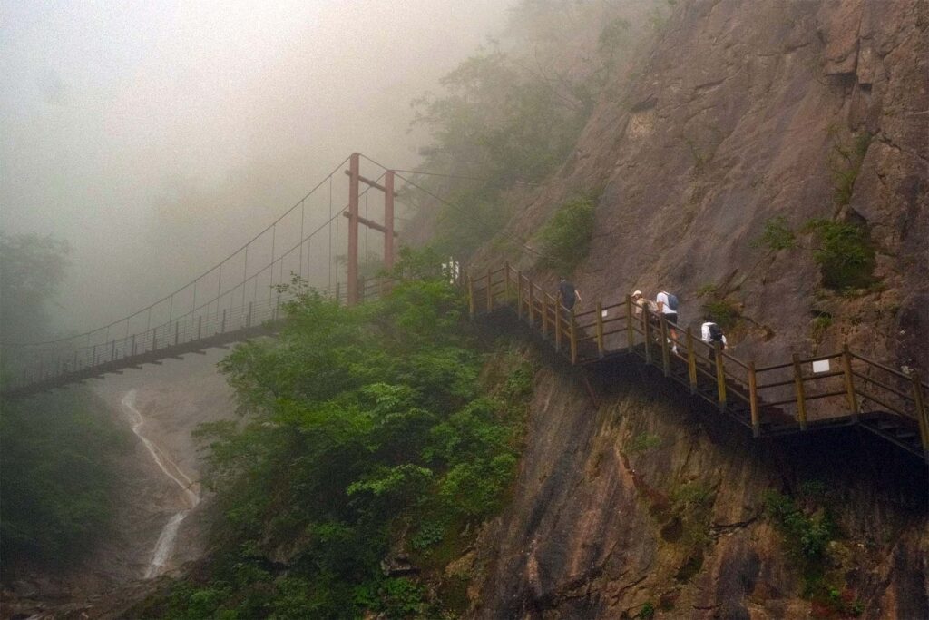 Sendero acondicionado a lo largo de una pared rocosa entre la niebla de las montañas de Seoraksan