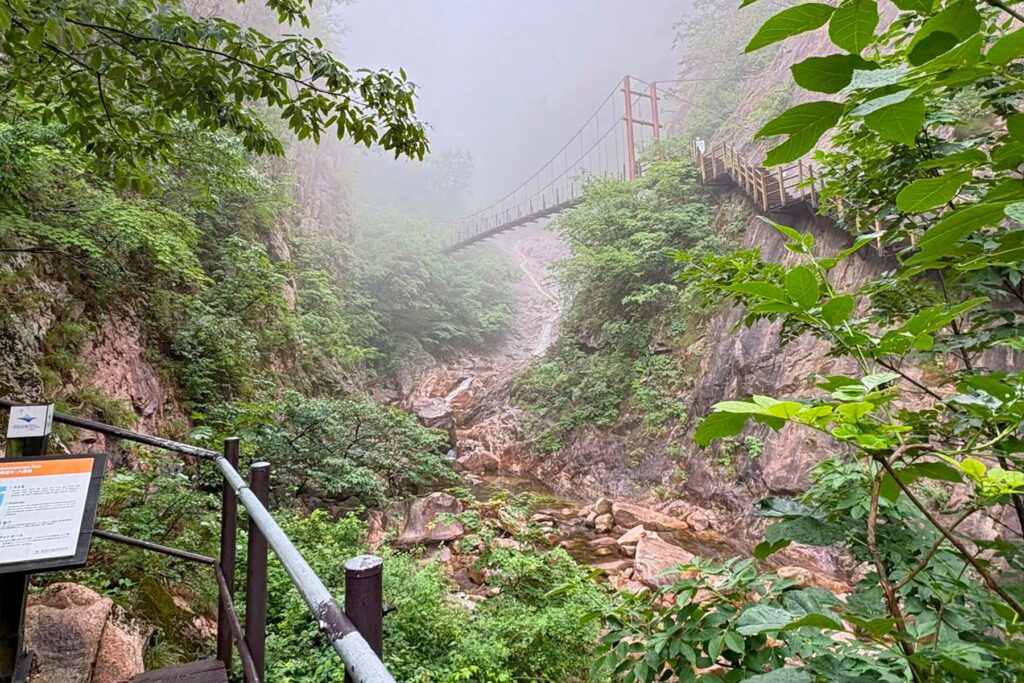 Sendero que bordea un desfiladero rocoso envuelto en niebla en el Parque Nacional de Seoraksan